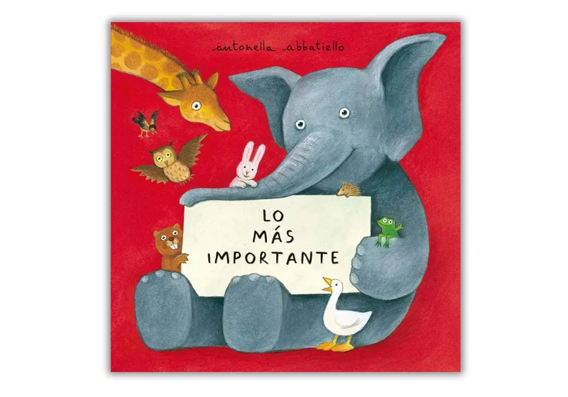 Portada del libro infantil "Lo más importante" de Antonella Abbatiello. La ilustración muestra un elefante azul sosteniendo un cartel con el título del libro, rodeado de varios animales como una jirafa, un búho, un conejo y un pato, sobre un fondo rojo vibrante.